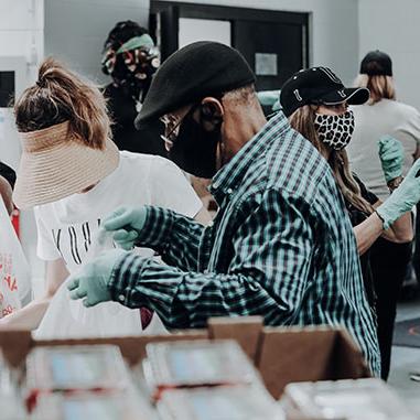 Volunteers assemble bags of food for refugees | photo by Joel Muniz